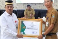 Drs. H. Achmad Nawawi, M.S.i Ketua Bazna Menyerahkan Piagam Penghargaan Kepada Disnaker  ( Foto : Istimewa )