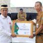 Drs. H. Achmad Nawawi, M.S.i Ketua Bazna Menyerahkan Piagam Penghargaan Kepada Disnaker  ( Foto : Istimewa )