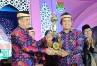 PJ Bupati Tangerang Andy Ony Ketika Menyerahkan Trophy Juara Umum Kepada Camat Mekar Baru Ansori. (Foto: Yadi/Portal MCA)