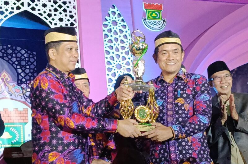 PJ Bupati Tangerang Andy Ony Ketika Menyerahkan Trophy Juara Umum Kepada Camat Mekar Baru Ansori. (Foto: Yadi/Portal MCA)